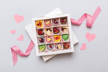Valentine day composition: sweet candy, with gift boxes with bow and red felt hearts, photo template, background. Top View with copy space.