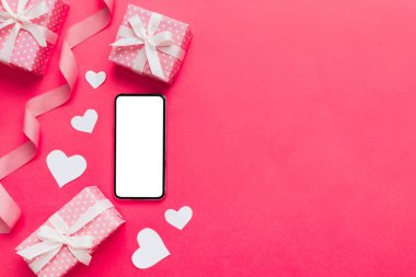 mobile phone with blank screen on colored background with hearts, valentine day concept top view flat lay.