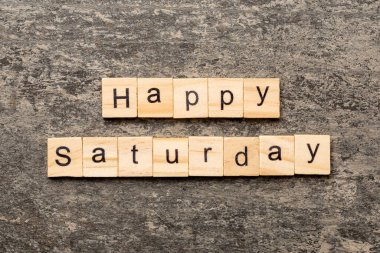 Ahşap blokta mutlu cumartesiler. Çimento masasındaki Cumartesi metnin kutlu olsun..
