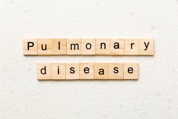 pulmonary disease word written on wood block. pulmonary disease text on table, concept.