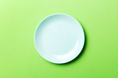 Renkli arka planın üst görüntüsü yiyecek için boş mavi tabak. Tasarımınız için alanı olan boş tabak.