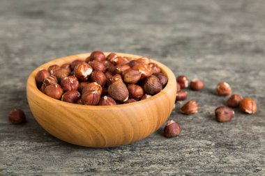 Wooden bowl full of hazelnuts on table background. Healthy eating concept. Super foods.