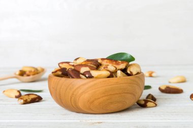 Fresh healthy Brazil nuts in bowl on colored table background. Top view Healthy eating bertholletia concept. Super foods.