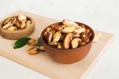 Fresh healthy Brazil nuts in bowl on colored table background. Top view Healthy eating bertholletia concept. Super foods.