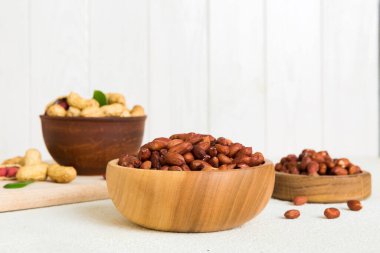 Fresh healthy peanuts in bowl on colored table background. Top view Healthy eating bertholletia concept. Super foods.