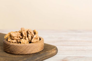 Fresh healthy walnuts in bowl on colored table background. Top view Healthy eating bertholletia concept. Super foods.