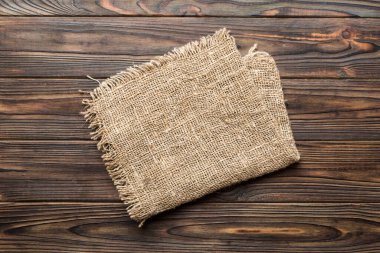 Old burlap fabric napkin, sackcloth on table background. top view with copy space.