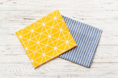 top view with yellow empty kitchen napkin isolated on table background. Folded cloth for mockup with copy space, Flat lay. Minimal style.