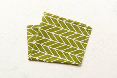 top view with green kitchen napkin isolated on table background. Folded cloth for mockup with copy space, Flat lay. Minimal style.