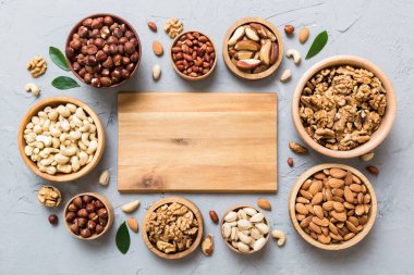 mixed nuts in wooden bowl. Mix of various nuts on colored background. pistachios, cashews, walnuts, hazelnuts, peanuts and brazil nuts.