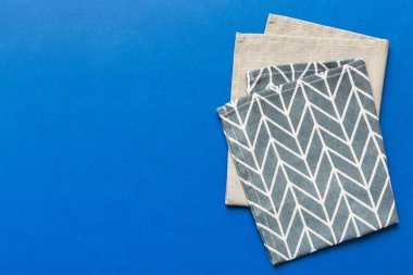 top view with blue kitchen napkin isolated on table background. Folded cloth for mockup with copy space, Flat lay. Minimal style.