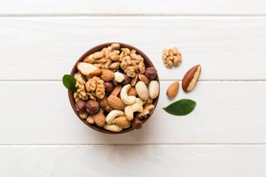 mixed nuts in bowl. Mix of various nuts on colored background. pistachios, cashews, walnuts, hazelnuts, peanuts and brazil nuts.