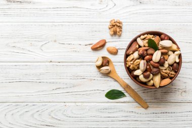 mixed nuts in bowl. Mix of various nuts on colored background. pistachios, cashews, walnuts, hazelnuts, peanuts and brazil nuts.