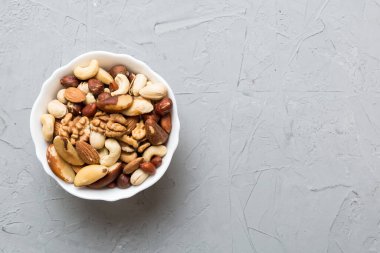 mixed nuts in bowl. Mix of various nuts on colored background. pistachios, cashews, walnuts, hazelnuts, peanuts and brazil nuts.
