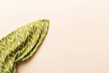 top view with green kitchen napkin isolated on table background. Folded cloth for mockup with copy space, Flat lay. Minimal style.