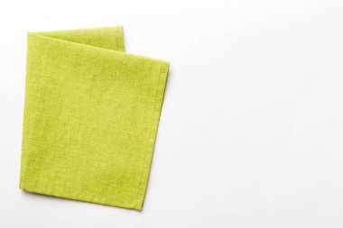 top view with green kitchen napkin isolated on table background. Folded cloth for mockup with copy space, Flat lay. Minimal style.