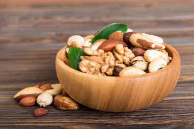 mixed nuts in bowl. Mix of various nuts on colored background. pistachios, cashews, walnuts, hazelnuts, peanuts and brazil nuts.