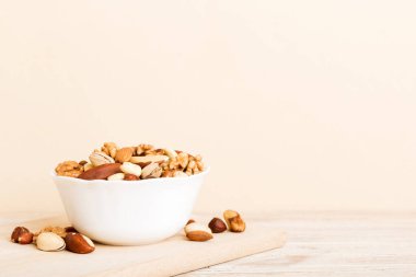 mixed nuts in bowl. Mix of various nuts on colored background. pistachios, cashews, walnuts, hazelnuts, peanuts and brazil nuts.
