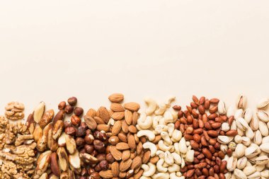 different nuts frame background. Close up, top view, flat lay with vopy space. Walnut, pistachios, almonds, hazelnuts and cashews.