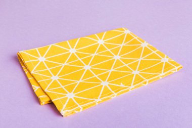 top view with yellow empty kitchen napkin isolated on table background. Folded cloth for mockup with copy space, Flat lay. Minimal style.