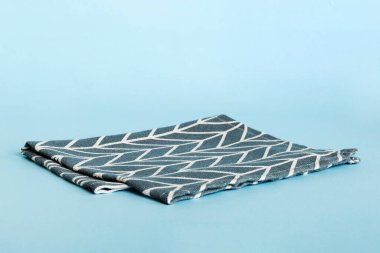 top view with blue kitchen napkin isolated on table background. Folded cloth for mockup with copy space, Flat lay. Minimal style.