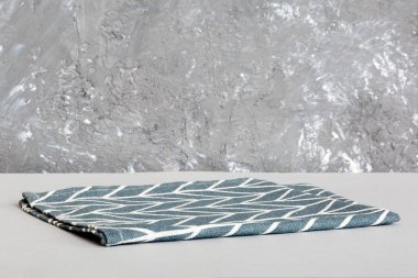 top view with blue kitchen napkin isolated on table background. Folded cloth for mockup with copy space, Flat lay. Minimal style.