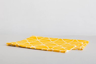 top view with yellow empty kitchen napkin isolated on table background. Folded cloth for mockup with copy space, Flat lay. Minimal style.