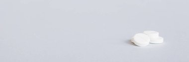 Renkli arka planda bir yığın beyaz hap. Tabletler masaya saçılmış. Kırmızı yumuşak jelatin kapsül yığını. Vitaminler ve beslenme takviyeleri konsepti.