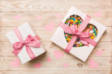 Valentine day composition: sweet candy, with gift boxes with bow and red felt hearts, photo template, background. Top View with copy space.