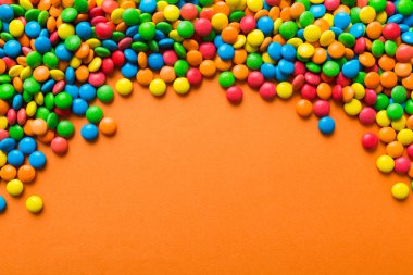 Renkli arka planda karışık renkli şeker koleksiyonu. Düz yerde, üst tarafta. Renkli çikolata kaplı şeker çerçevesi.