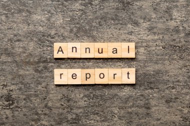 Tahta blokta yıllık rapor yazılıydı. Deksing, konsept için çimento masadaki yıllık rapor metni.