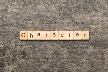 Tahta bloğa yazılmış bir kelime. Çimento sehpası üzerindeki CHARACTER metin desing, konsept.