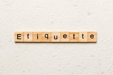 Tahta blokta ETIQUETTE kelimesi yazıyor. Beton masadaki ETIQUETTE metin desing, konsept için.