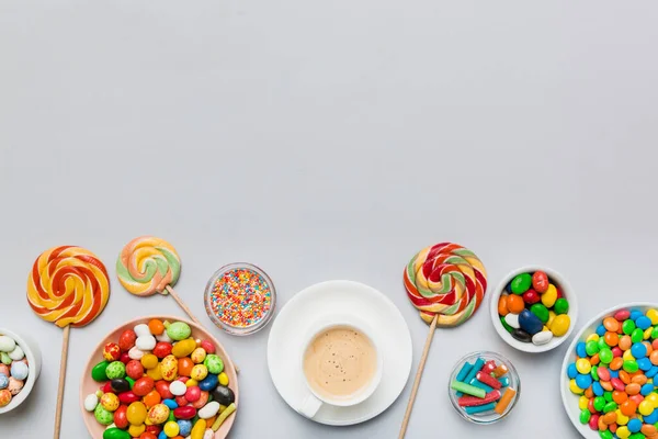 stock image Coffee cup with chocolates and colored candy. Top view on table background with copy space.