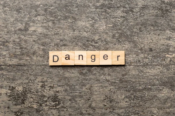 Niebezpieczne Słowo Napisane Drewnianym Bloku Niebezpieczny Tekst Stole Cementowym Projektowania — Zdjęcie stockowe