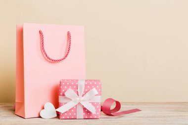 Shopping bag with gift box on colored background perspecrive view. Space for text holiday concept.