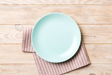 Renkli arkaplanda üst görünüm yiyecek için mavi tabak üzerinde boş. Tasarımınız için boşluk olan peçeteye boş tabak.