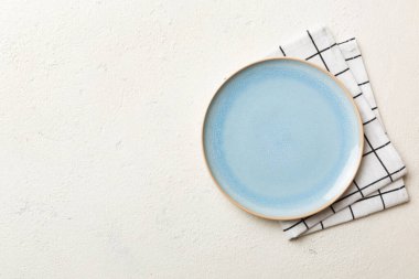 Renkli arkaplanda üst görünüm yiyecek için mavi tabak üzerinde boş. Tasarımınız için boşluk olan peçeteye boş tabak.