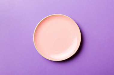 Renkli arka planın üst görüntüsü. Yemek için boş pembe tabak. Tasarımınız için alanı olan boş tabak.