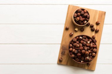 Wooden bowl full of hazelnuts on table background. Healthy eating concept. Super foods.