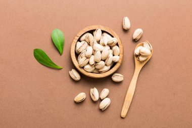Fresh healthy Pistachios in bowl on colored table background. Top view. Healthy eating concept. Super foods.
