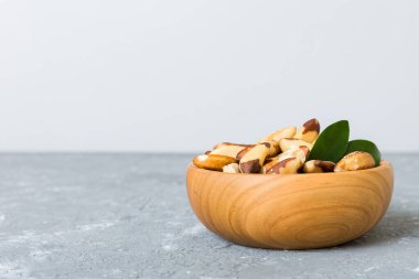 Fresh healthy Brazil nuts in bowl on colored table background. Top view Healthy eating bertholletia concept. Super foods.