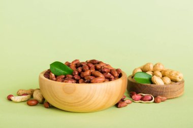 Fresh healthy peanuts in bowl on colored table background. Top view Healthy eating bertholletia concept. Super foods.