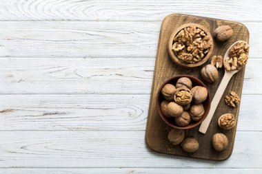 Fresh healthy walnuts in bowl on colored table background. Top view Healthy eating bertholletia concept. Super foods.