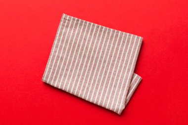 top view with red empty kitchen napkin isolated on table background. Folded cloth for mockup with copy space, Flat lay. Minimal style.