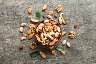 mixed nuts in bowl. Mix of various nuts on colored background. pistachios, cashews, walnuts, hazelnuts, peanuts and brazil nuts.
