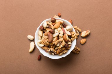 mixed nuts in bowl. Mix of various nuts on colored background. pistachios, cashews, walnuts, hazelnuts, peanuts and brazil nuts.