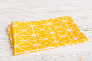 top view with yellow empty kitchen napkin isolated on table background. Folded cloth for mockup with copy space, Flat lay. Minimal style.