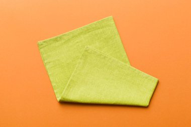 top view with green kitchen napkin isolated on table background. Folded cloth for mockup with copy space, Flat lay. Minimal style.