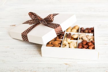Various varieties of nuts lying in paper box on table background. Top view. Healthy food. Close up, copy space, top view, flat lay. Walnut, pistachios, almonds, hazelnuts and cashews.